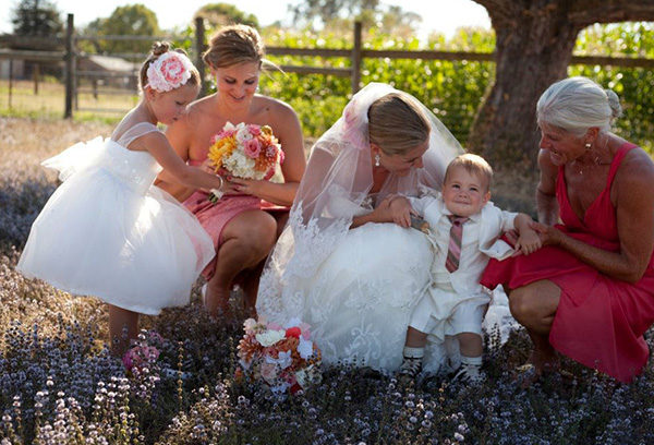 A bride and her family sitting in the grass.