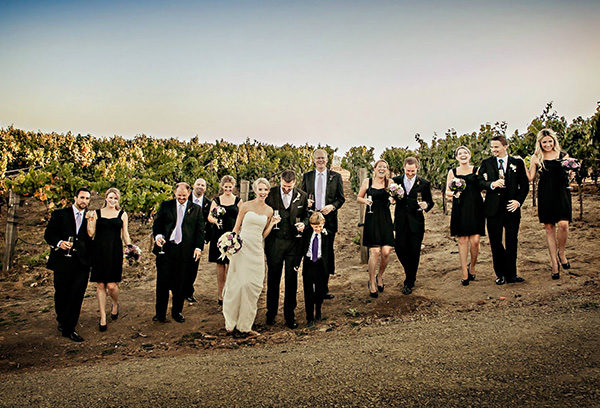 A group of people in suits and dresses standing on top of a hill.
