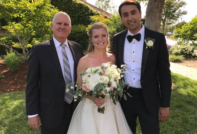 A bride and groom with their father